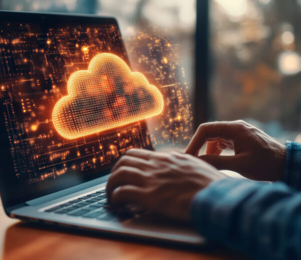 Person typing on a laptop with a glowing cloud computing interface and digital data network visualisation