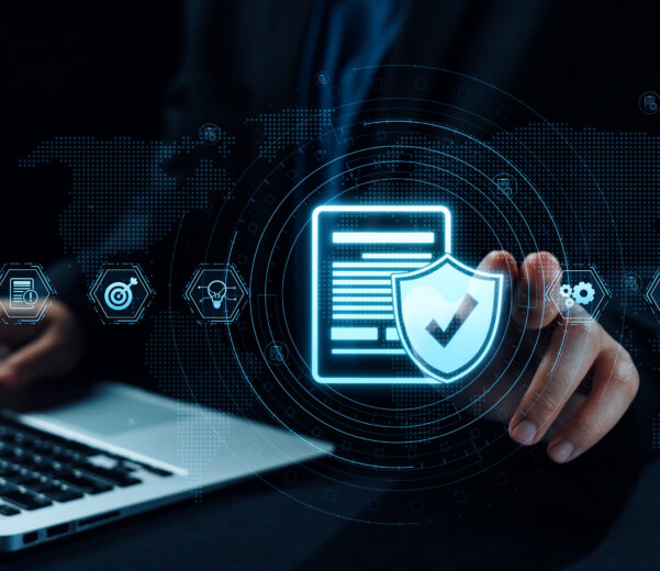 Cybersecurity concept showing a digital shield with checkmark over a laptop, representing data protection and compliance